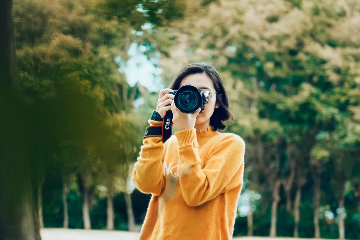 A young photographer framing a shot with a camera